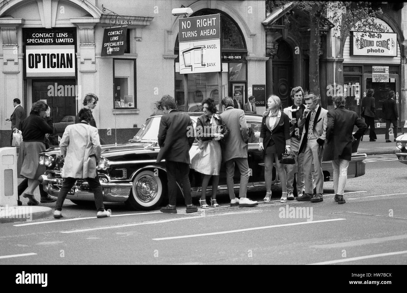 Gli appassionati di musica di ammirare un vintage auto negli Stati Uniti durante il Rock and Roll campagna Radio marzo attraverso il centro di Londra, in Inghilterra il 15 maggio 1976. La campagna mira a ottenere più vintage rock and roll musica riprodotta su BBC Radio. Foto Stock