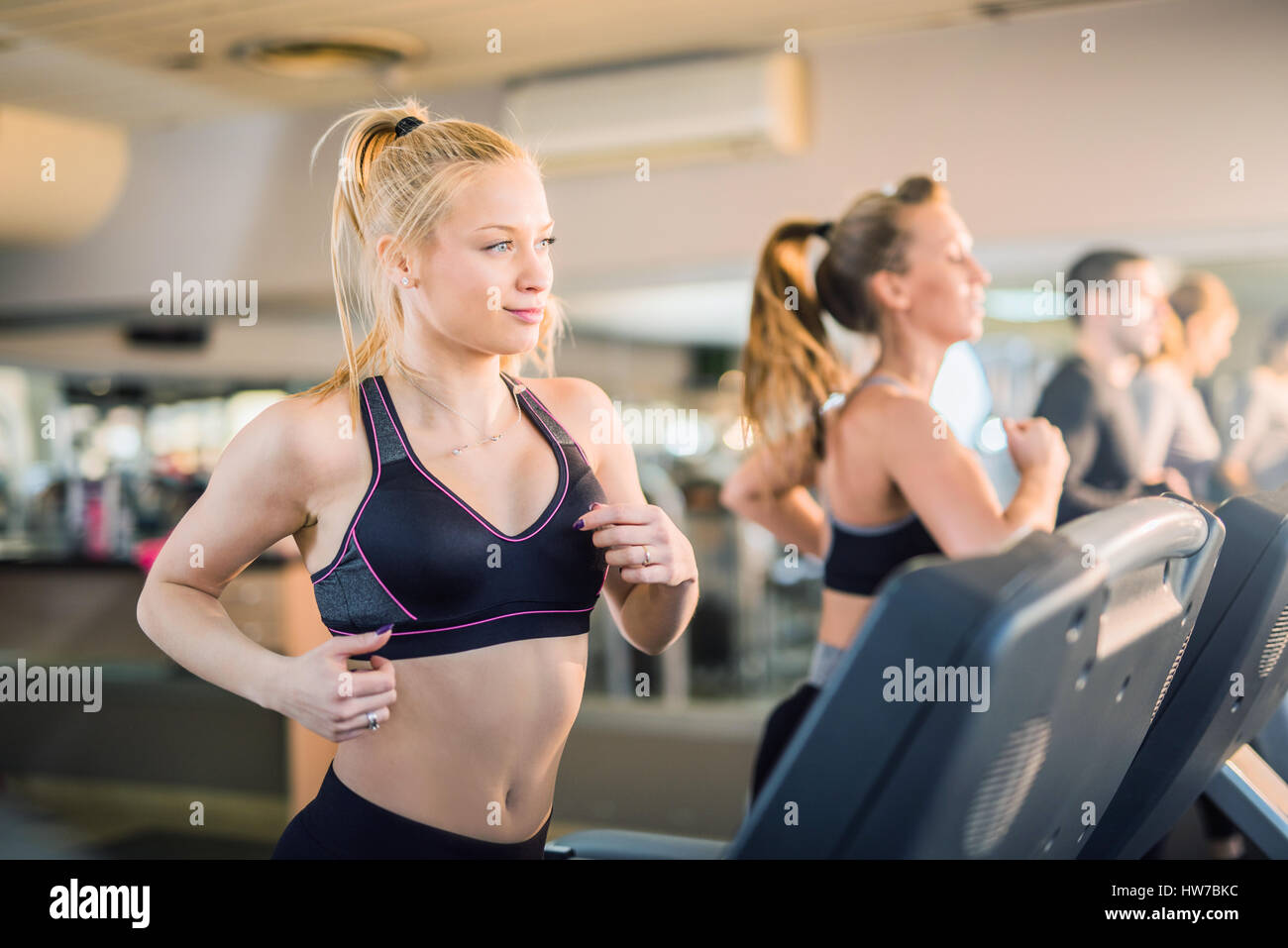 Giovane e bella gente in esecuzione su un tapis roulant nel club salute Foto Stock
