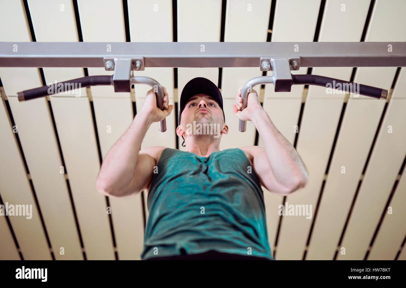 Giovane uomo facendo pull-up nel club salute Foto Stock