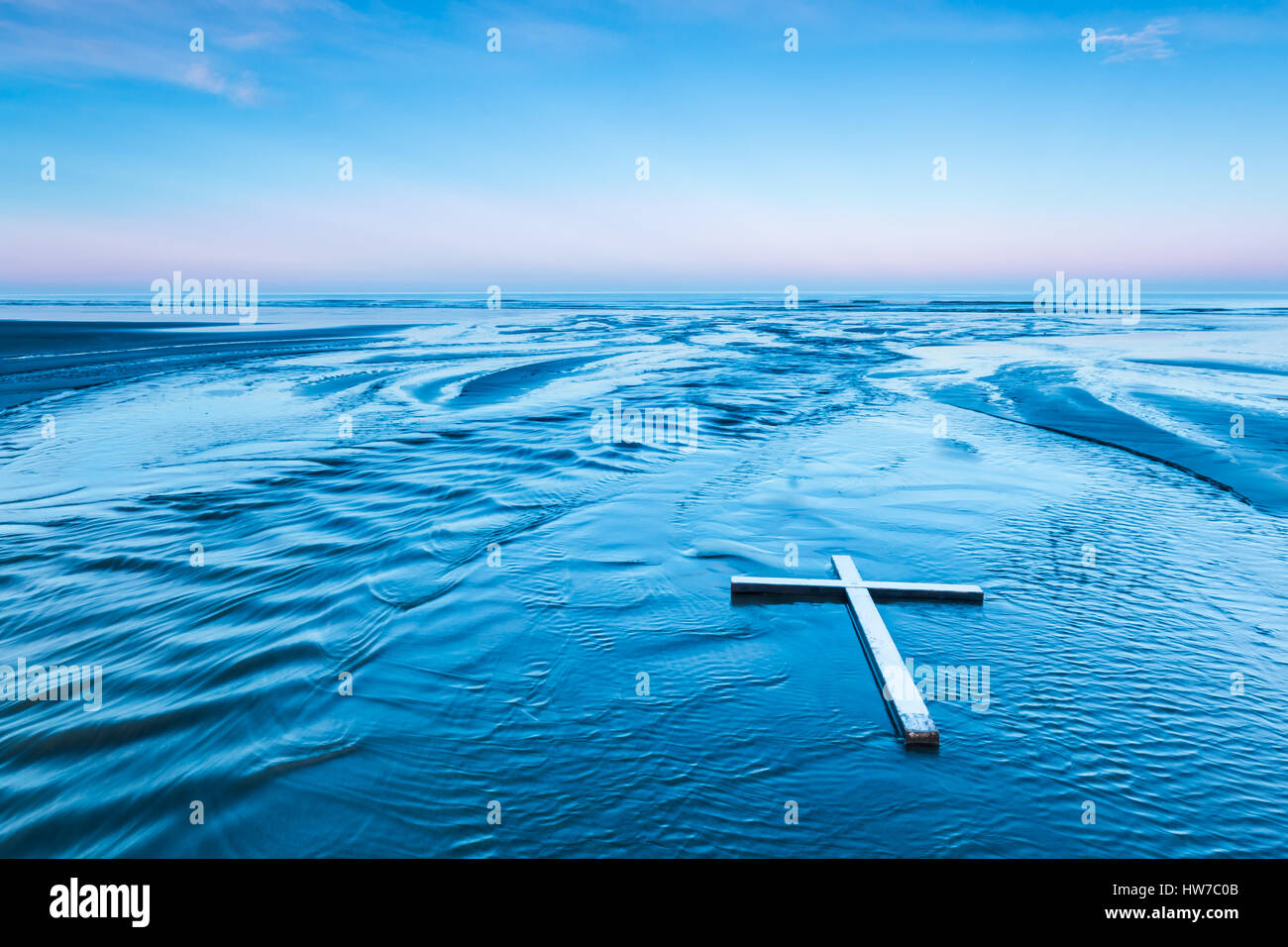 Croce bianca che stabilisce in un fiume che scorre verso il mare, Foto Stock