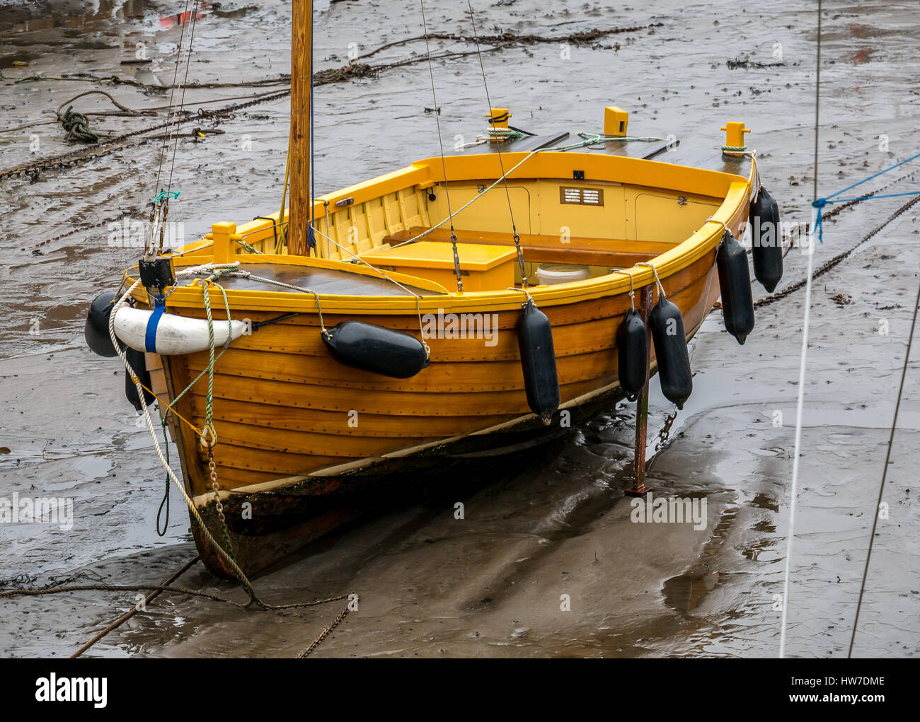 Tradizionale in legno verniciato in barca a vela nel fango in porto con la bassa marea, North Berwick, East Lothian, Scozia, Regno Unito Foto Stock