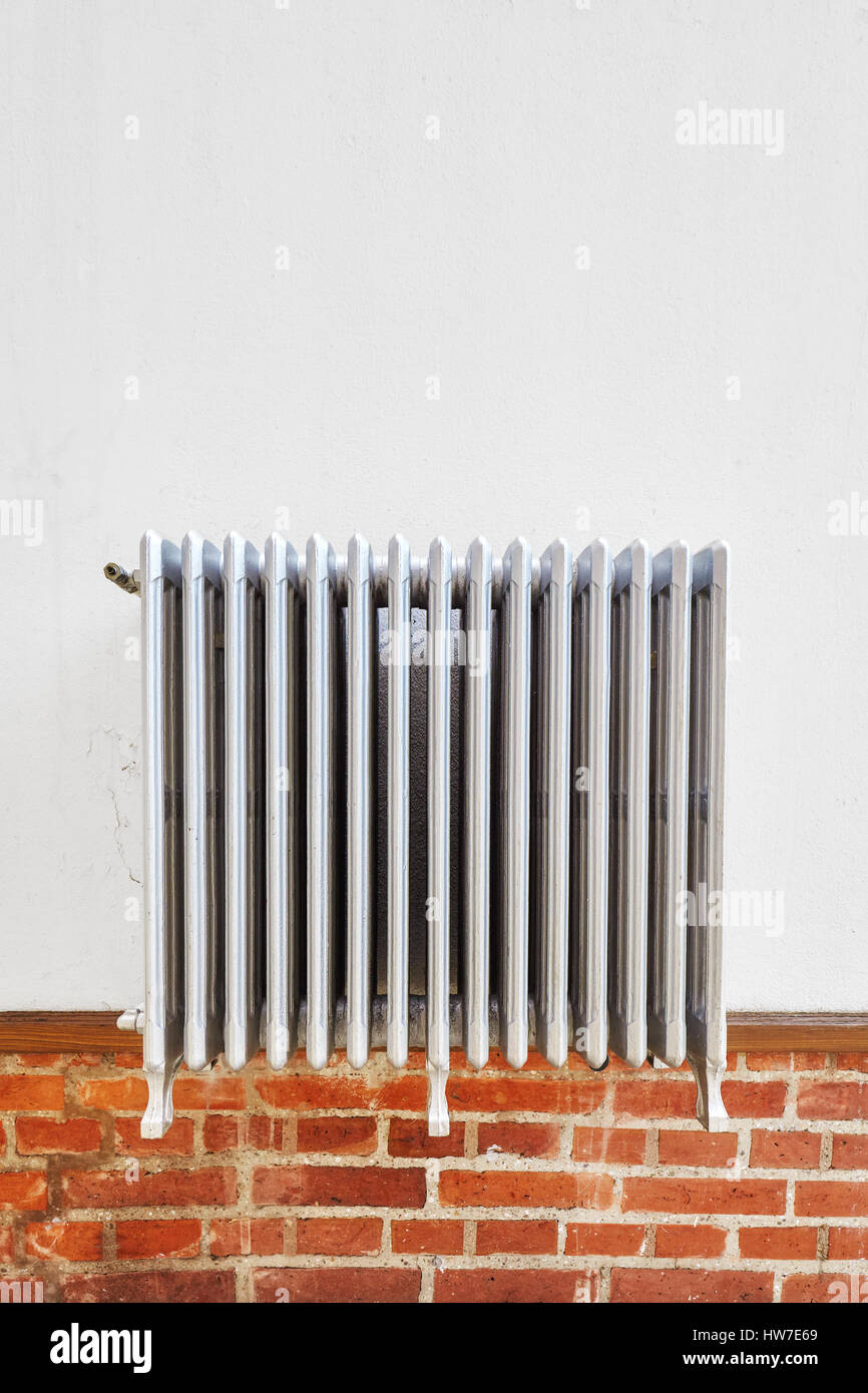 Vecchio radiatore di riscaldamento su una parete, spazio per il testo. Foto Stock