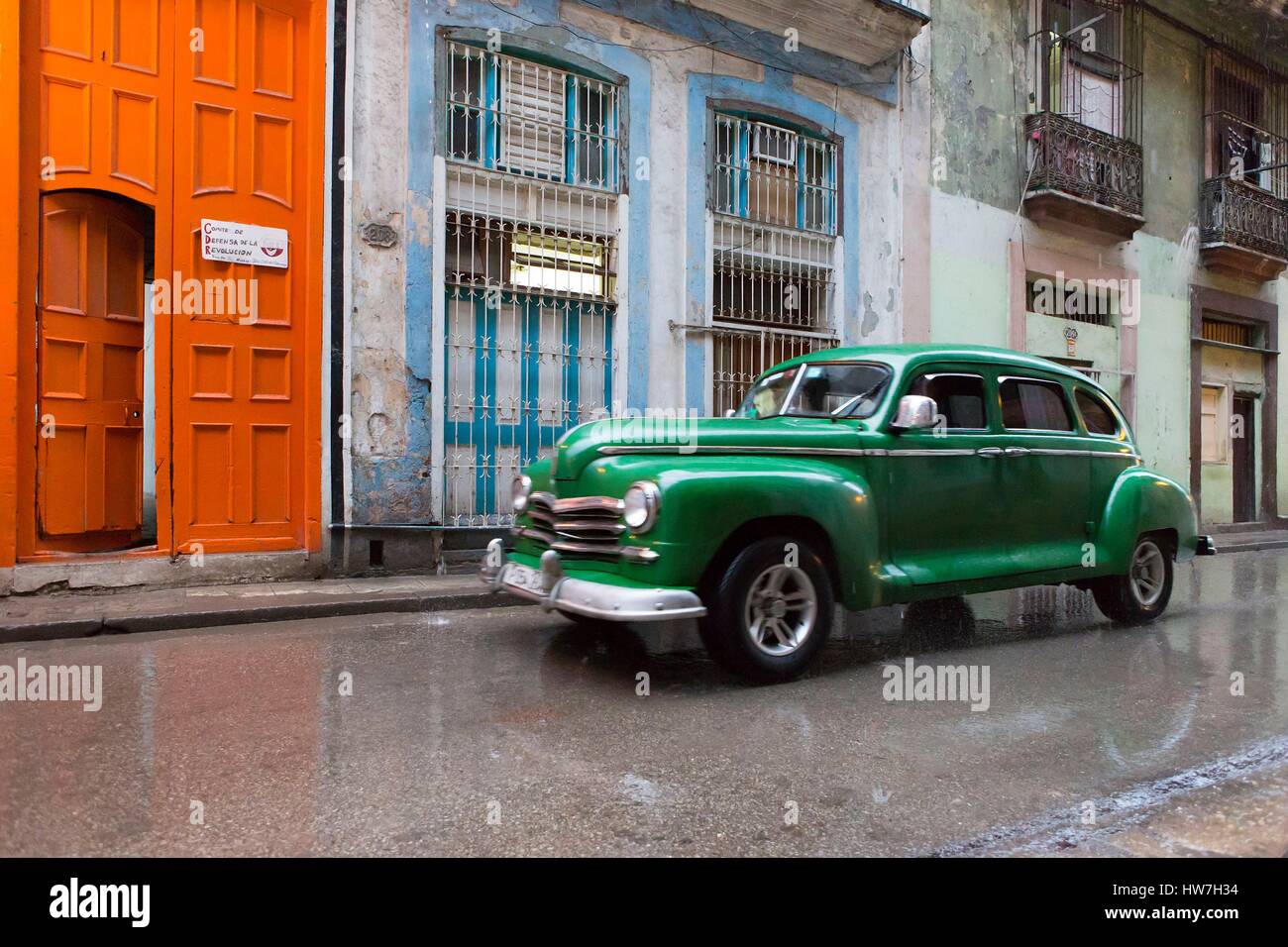 Cuba, Ciudad de la Habana Province, La Havana, La Habana Vieja district elencati come patrimonio mondiale dall' UNESCO, vettura americana sotto la pioggia lungo una porta dipinta da artista francese Daniel Buren durante il 2015 l'arte contemporanea evento biennale Foto Stock