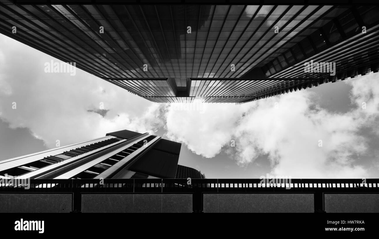 Un'immagine monocromatica guardando il cielo in una stretta intercapedine tra vetro di salita torri di uffici a Sydney in Australia Foto Stock