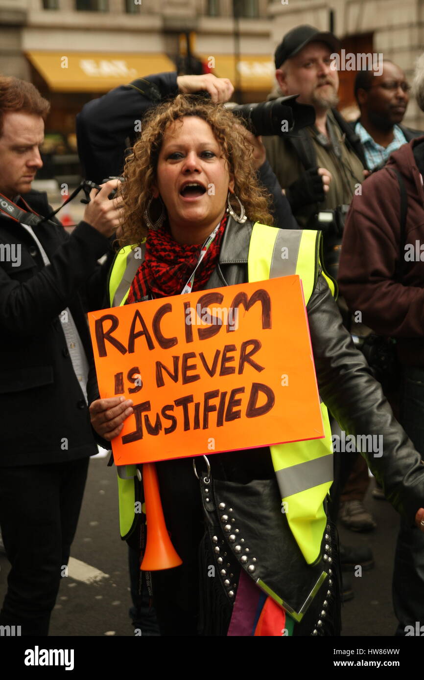 Londra, UK, 18 marzo 2017. Campagna di supporto del gruppo fino al razzismo detiene una marcia attraverso il centro di Londra per contrassegnare ONU contro il razzismo al giorno. Uno dei commissari di percorso sorregge un cartello che dice: "Il razzismo non è mai giustificato". Roland Ravenhill/ Alamy Live News Foto Stock