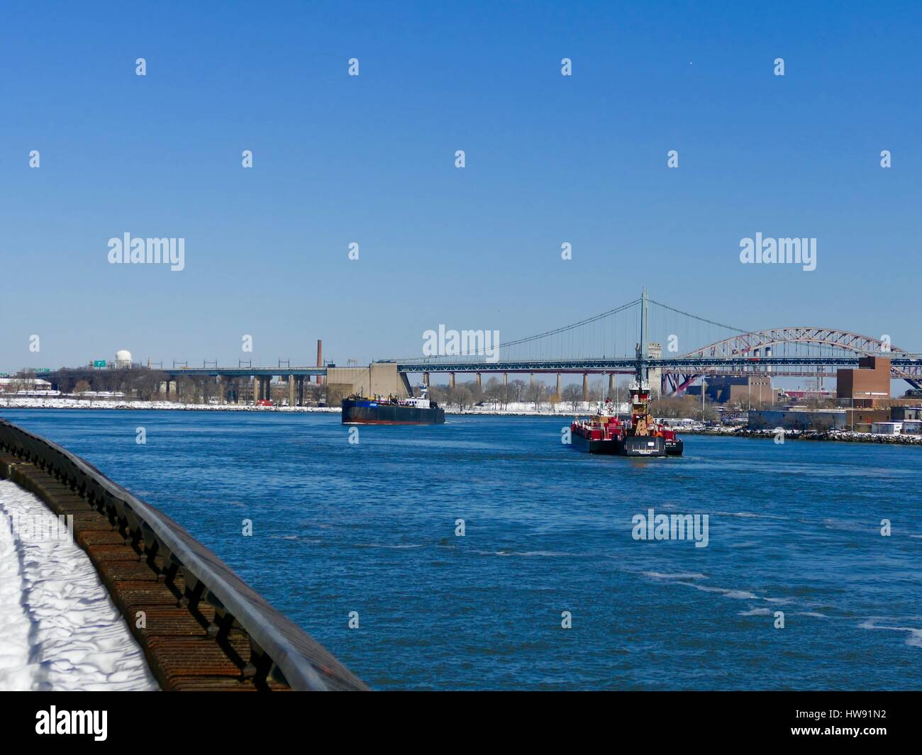 East River commerciale del traffico in barca con RFK bridge in background. La città di New York, New York, Stati Uniti d'America Foto Stock