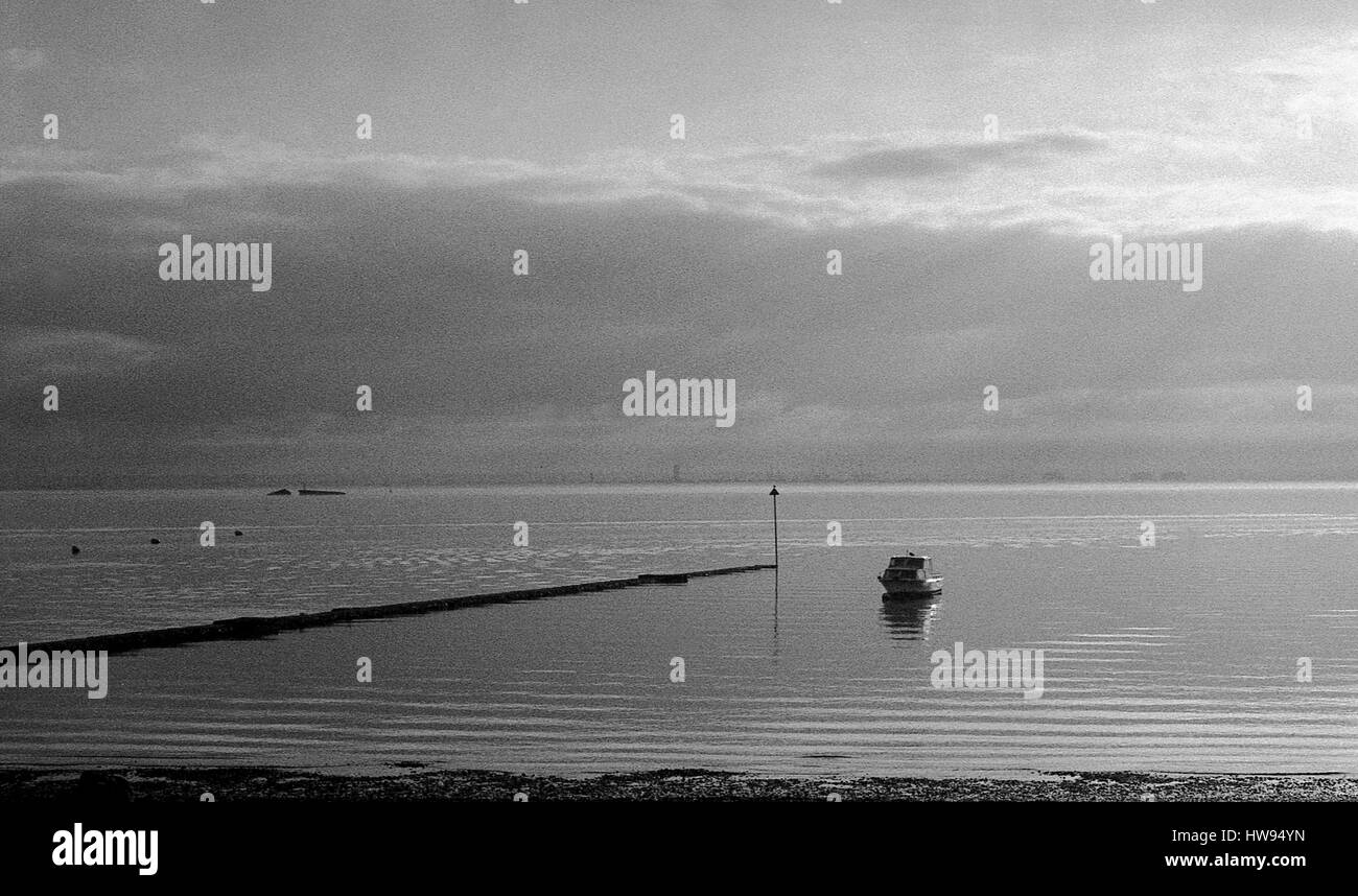 Foto in bianco e nero di una barca sulle calme acque di estuario del Tamigi, Shoeburyness, Essex. Foto Stock