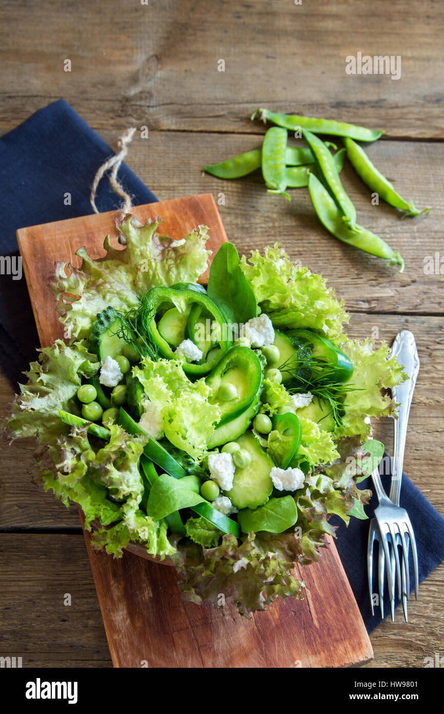Organico verde mista insalata di verdure con formaggio feta in ciotola di legno close up - Dieta sana Organica Vegana cibo vegetariano insalata di pasto Foto Stock