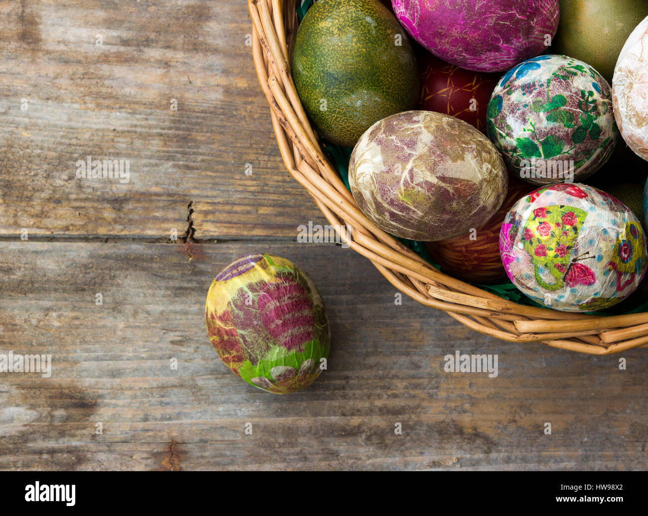 Gruppo di colorate uova di Pasqua decorate con fiori realizzata dal decoupage tecnica in un cesto su sfondo di legno/ vista superiore Foto Stock