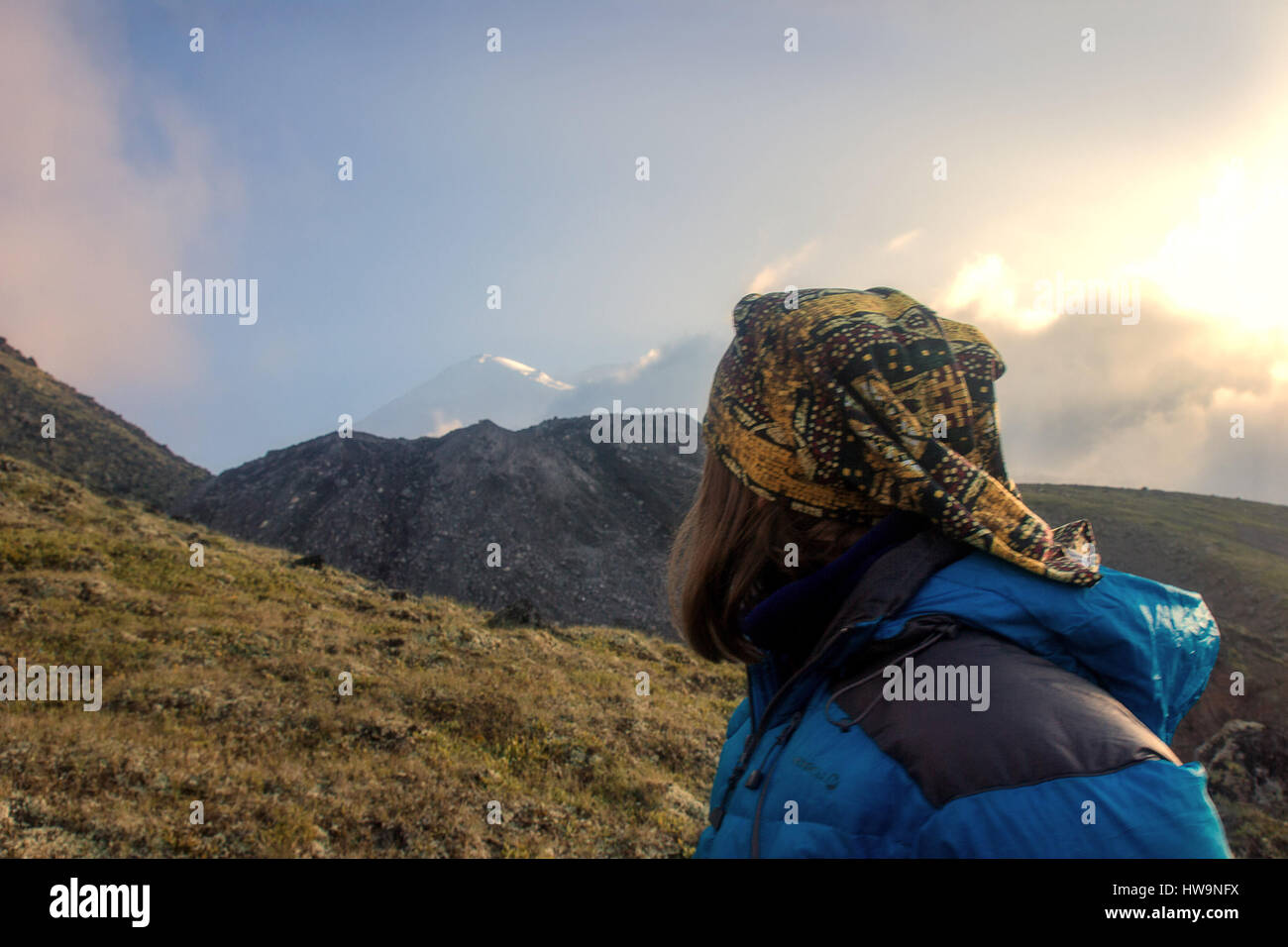 Ragazza per turisti in cerca a Mount Elbrus davanti alla sua difficile arrampicata Foto Stock