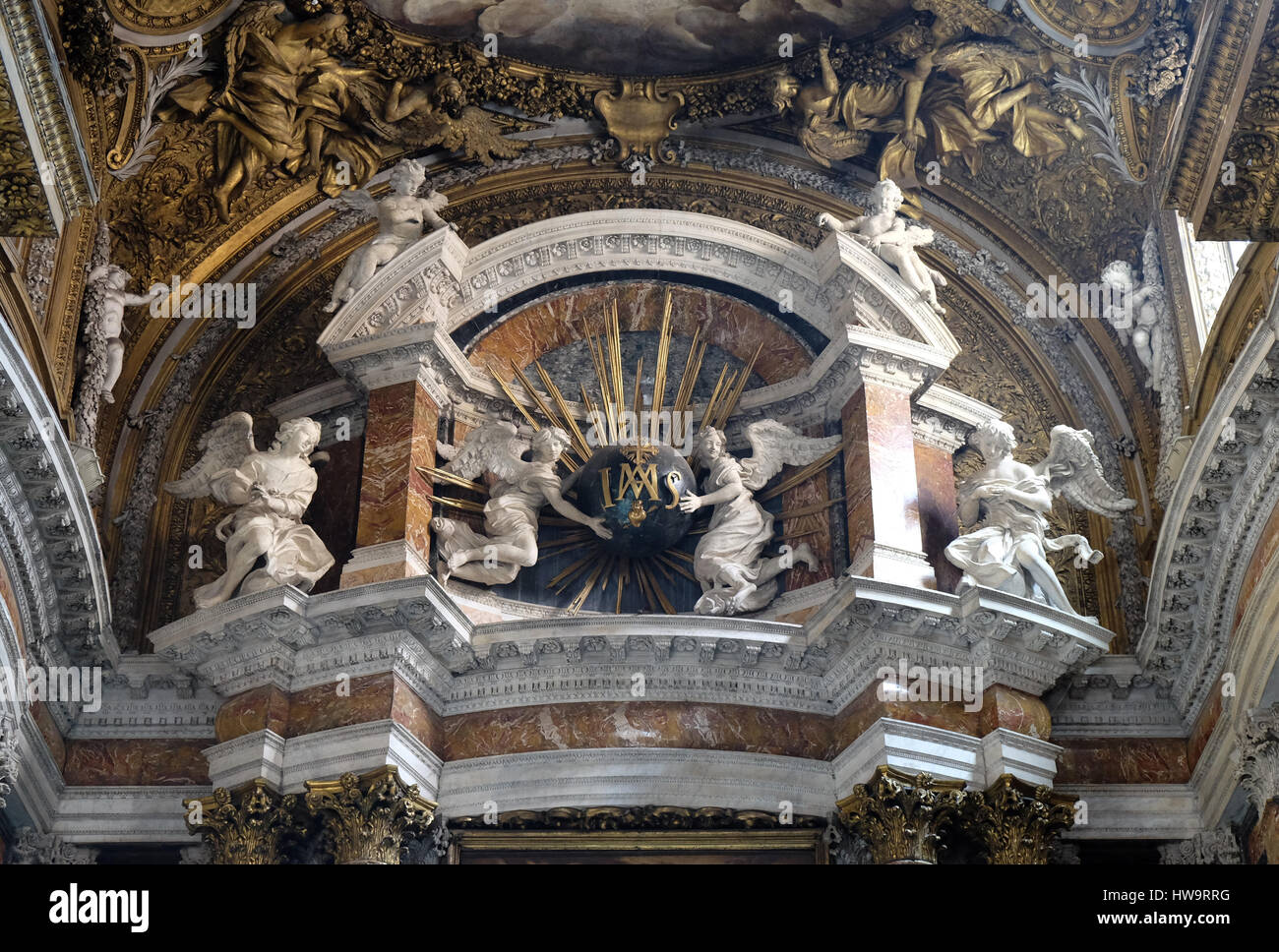 Angeli tenendo un globo con raggi dorati, e iniziali IMAS per i nomi di Gesù e Maria, altare maggiore nella chiesa Gesu e Maria a Roma Foto Stock
