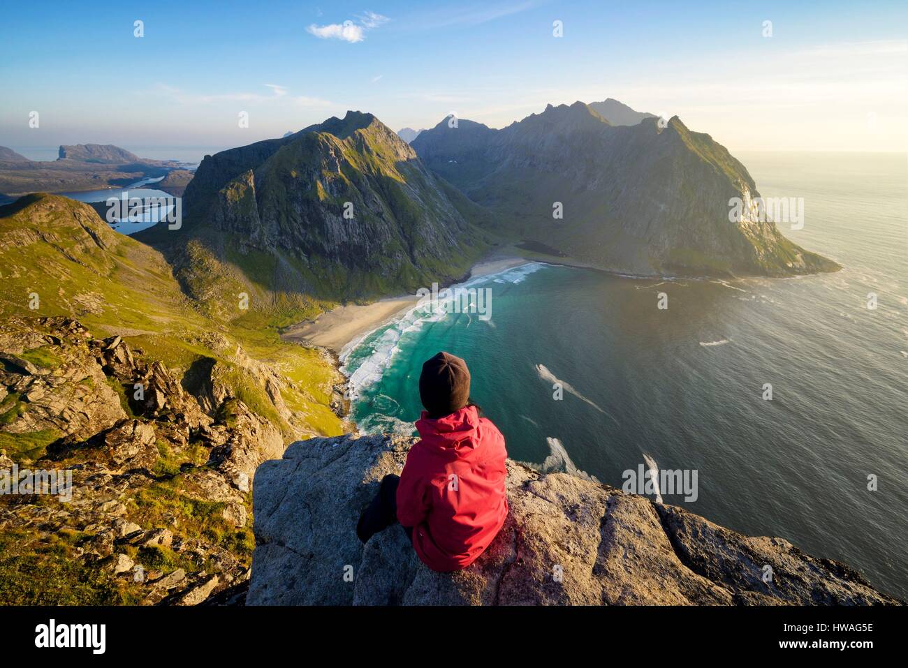 Norvegia, Nordland, isole Lofoten, isola Moskenesoy, donna escursionista presso la vetta del monte Ryten (543m), la spiaggia isolata di Kvalvika al di sotto di Foto Stock