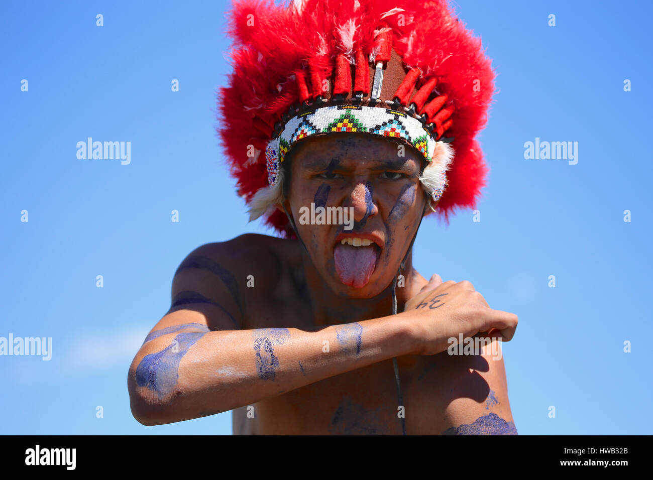 Native American Indian indossando blu vernice di guerra e indossando red feather cerimoniale abito di testa Crazy Horse reenactor nella battaglia di Little Bighorn Montana Foto Stock