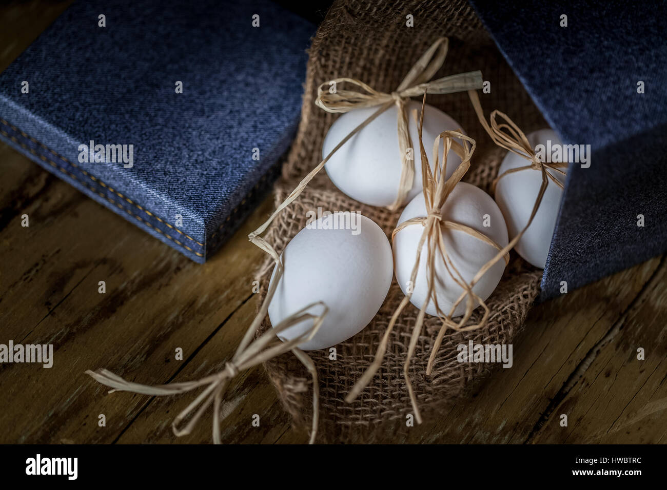 Bianco uova fresche legata con una stringa su un sfondo di legno ,il fuoco selettivo immagine concetto di pasqua Foto Stock