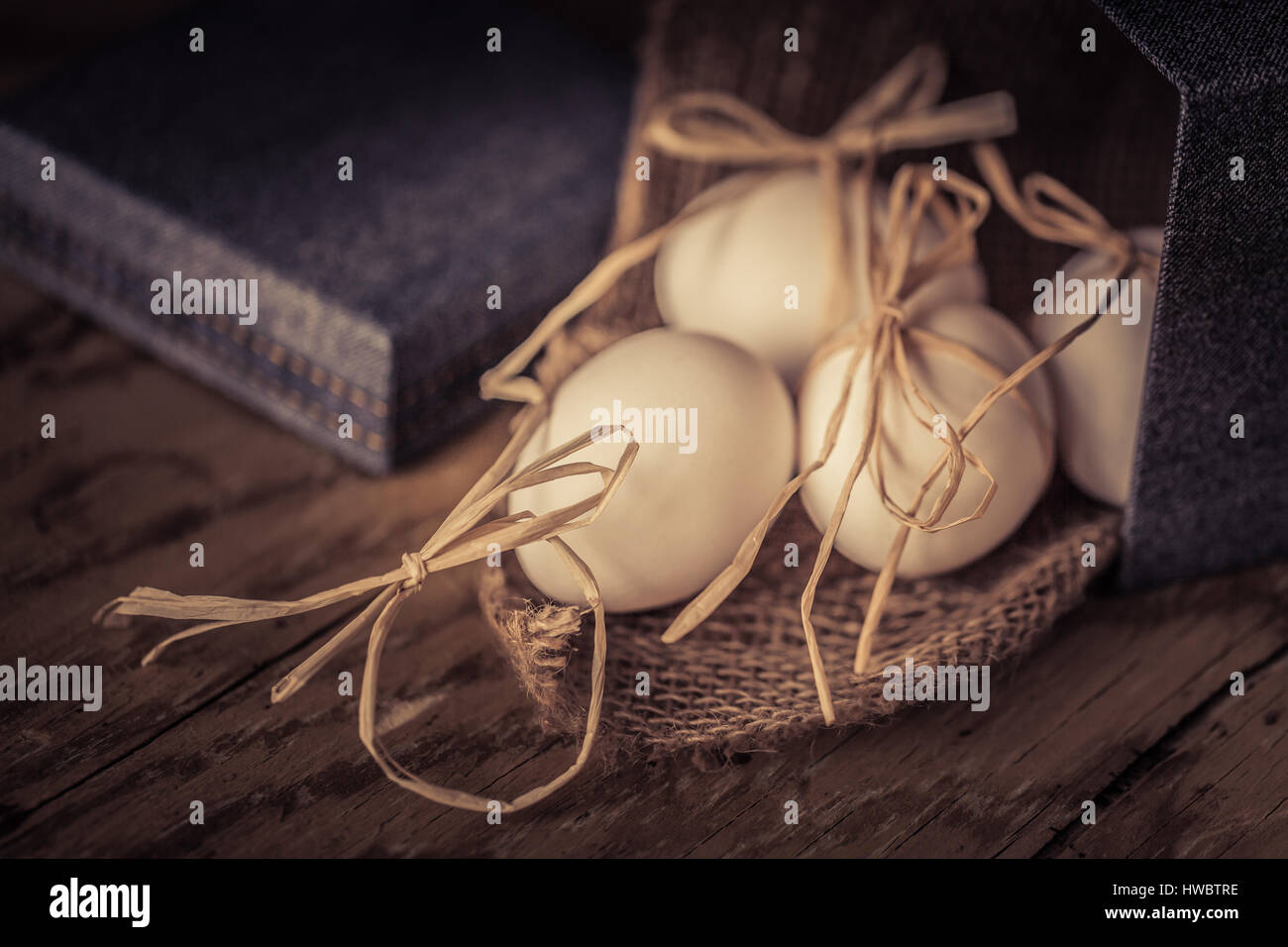 Bianco uova fresche legata con una stringa su un sfondo di legno ,il fuoco selettivo immagine vintage concetto di pasqua Foto Stock