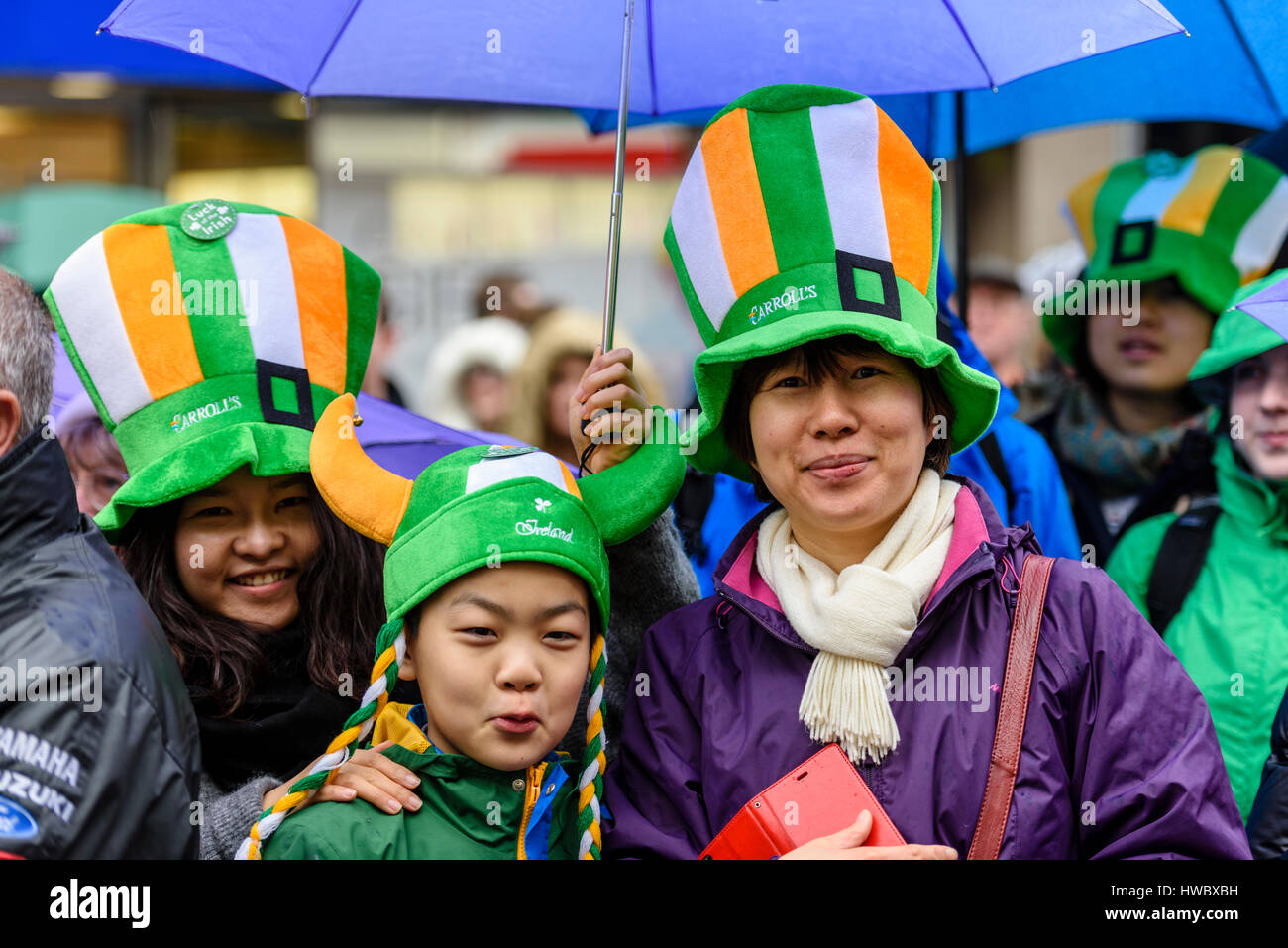 Belfast, Irlanda del Nord. 17 mar 2016 - i turisti cinesi usura verde, bianco e giallo cappelli per festeggiare San Patrizio. Foto Stock