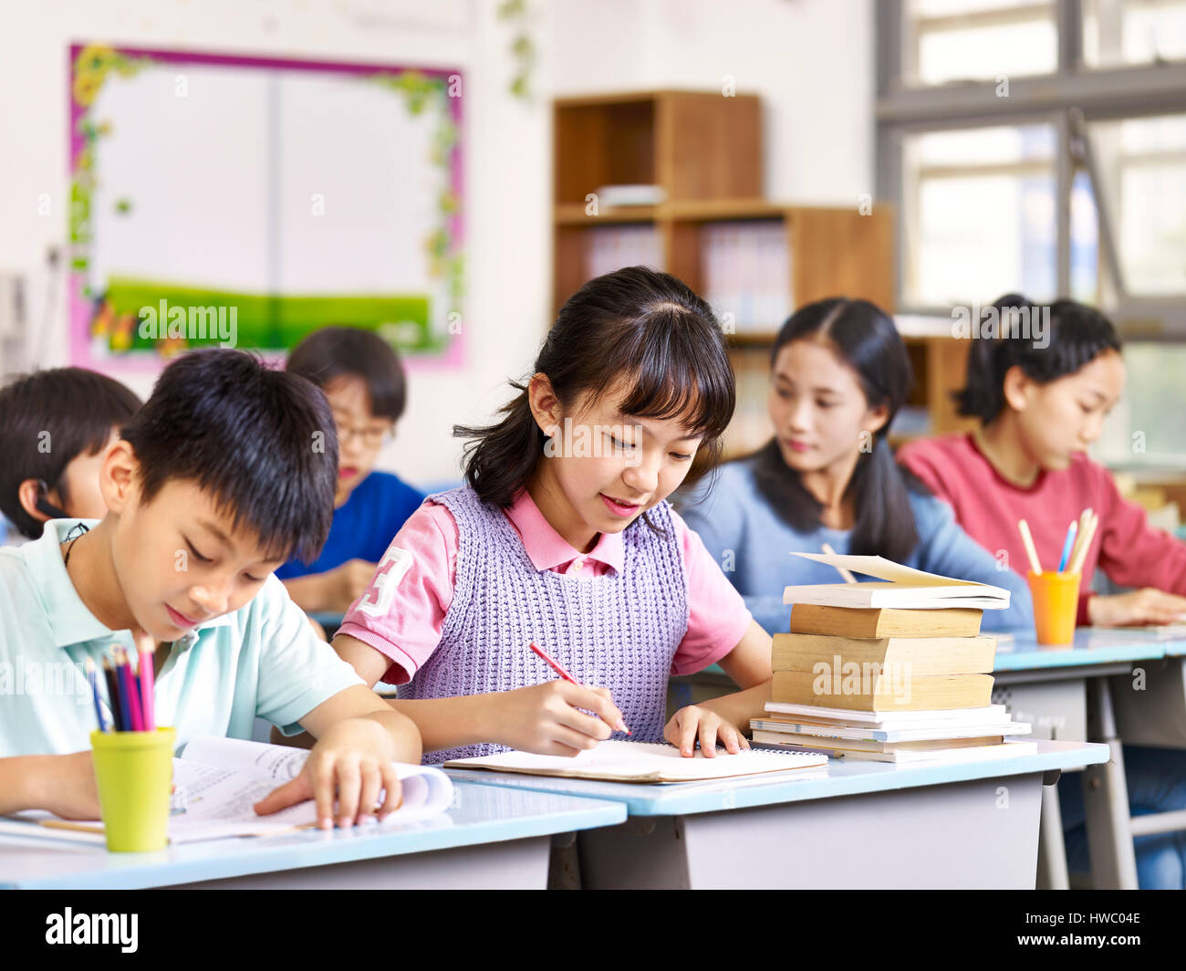 Gruppo di asiatici scuola primaria i ragazzi e le ragazze che studiano in classe. Foto Stock