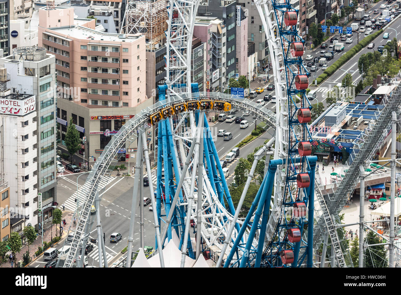 TOKYO, Giappone - Agosto 17, 2015: le persone godono di un roller coaster ride in all'aperto un parco dei divertimenti sulla parte superiore di un edificio nel cuore di Tokyo, Giappone Foto Stock