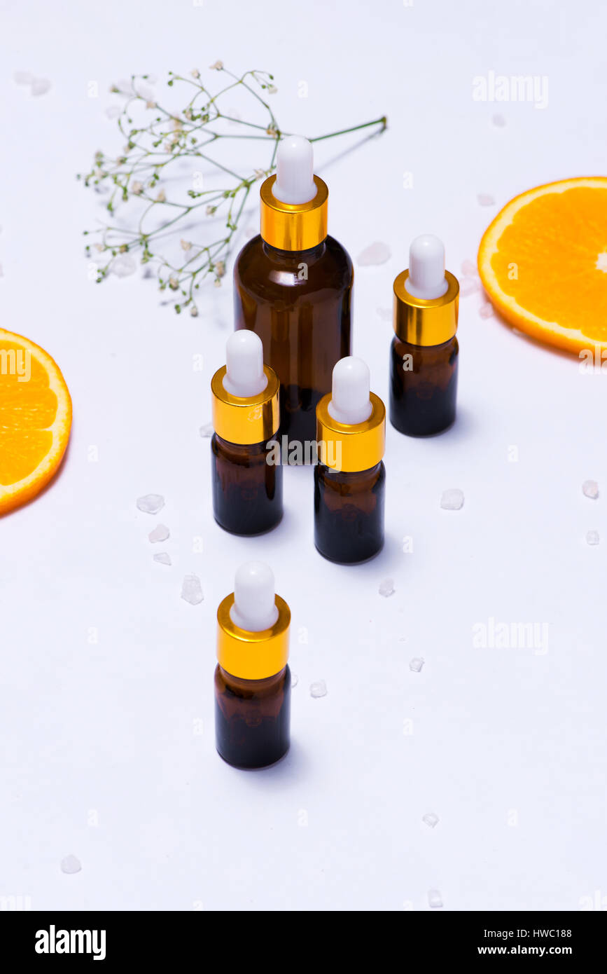 Il Branding mock-up. Olio essenziale naturale, bottiglia di cosmetici contenitori con fettine di arancia. Foto Stock