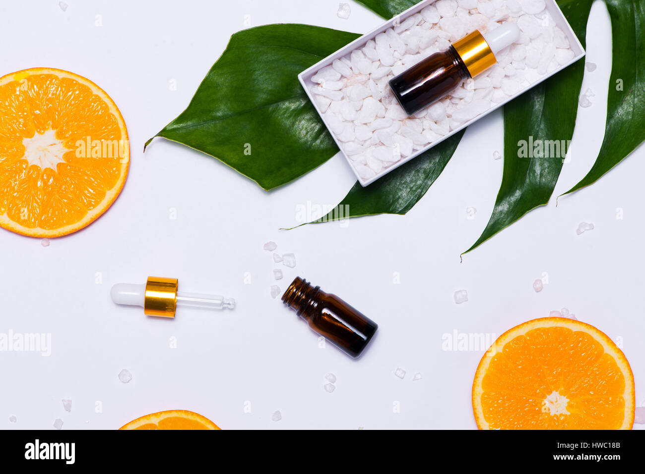 Il Branding mock-up. Olio essenziale naturale, bottiglia di cosmetici contenitori con fettine di arancia. Foto Stock