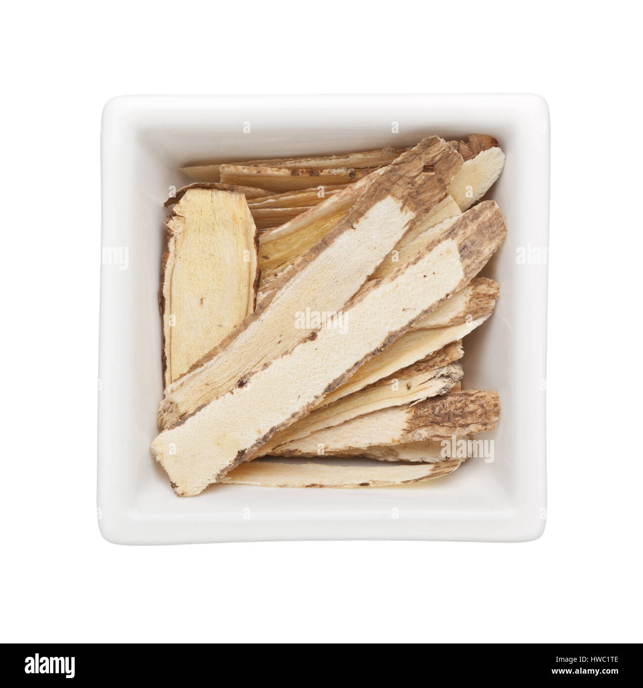 Medicina Tradizionale Cinese - Huang Qi astragalo (root) in un recipiente quadrato isolato su sfondo bianco Foto Stock