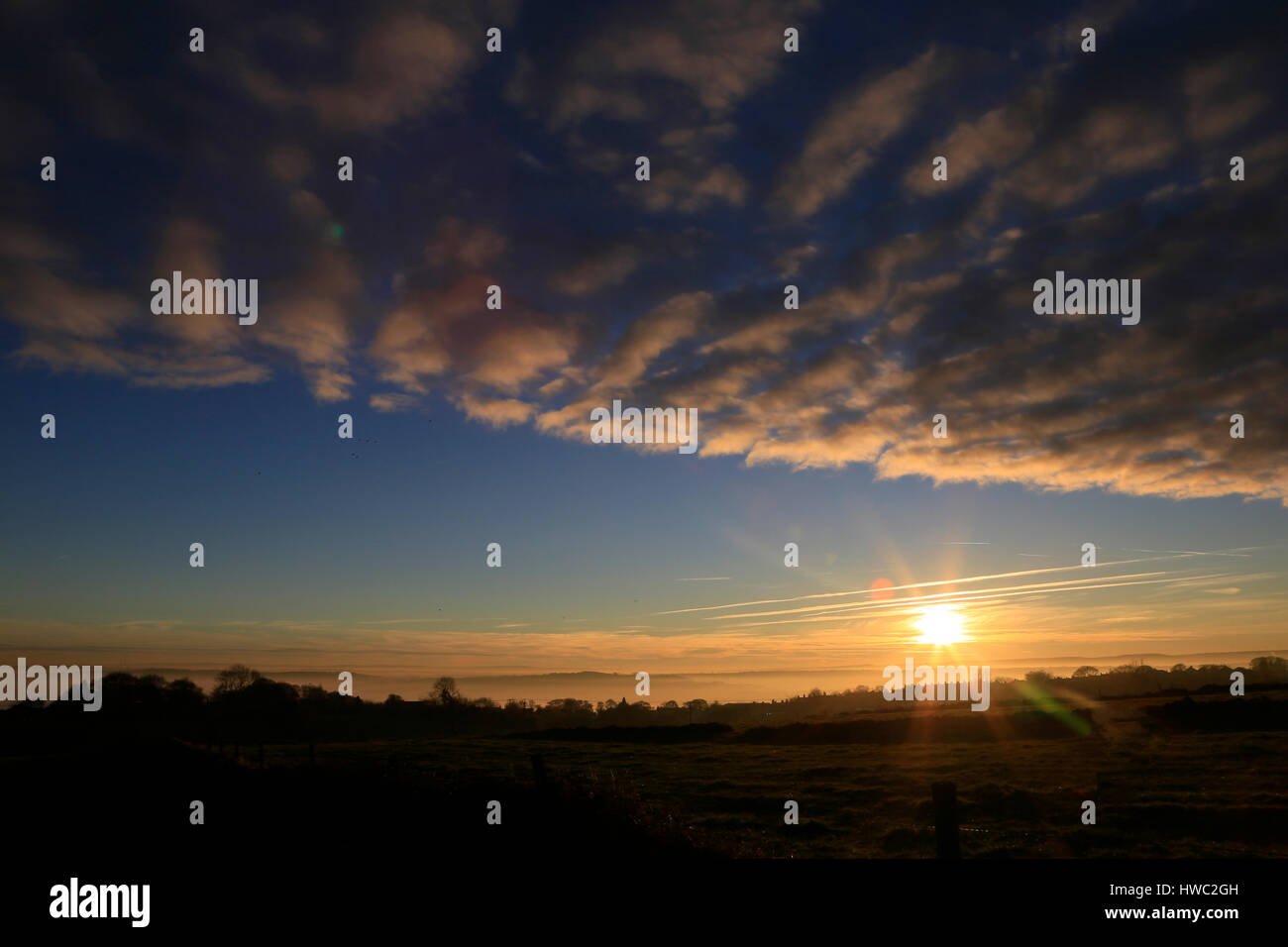 Tramonto spettacolare con il sole, le nuvole e cielo blu Foto Stock