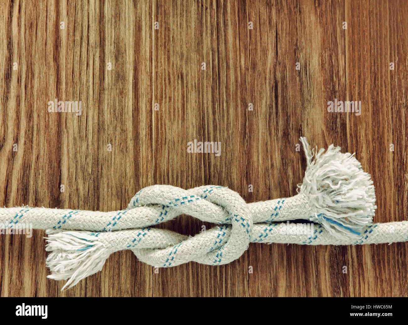 Bianco con corda nautica reef nodo su grunge sfondo di legno con lo spazio vuoto per il testo. Foto Stock