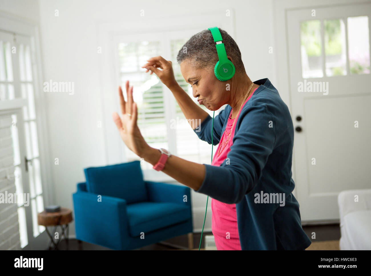 Senior donna ascoltare musica sulle cuffie Foto Stock
