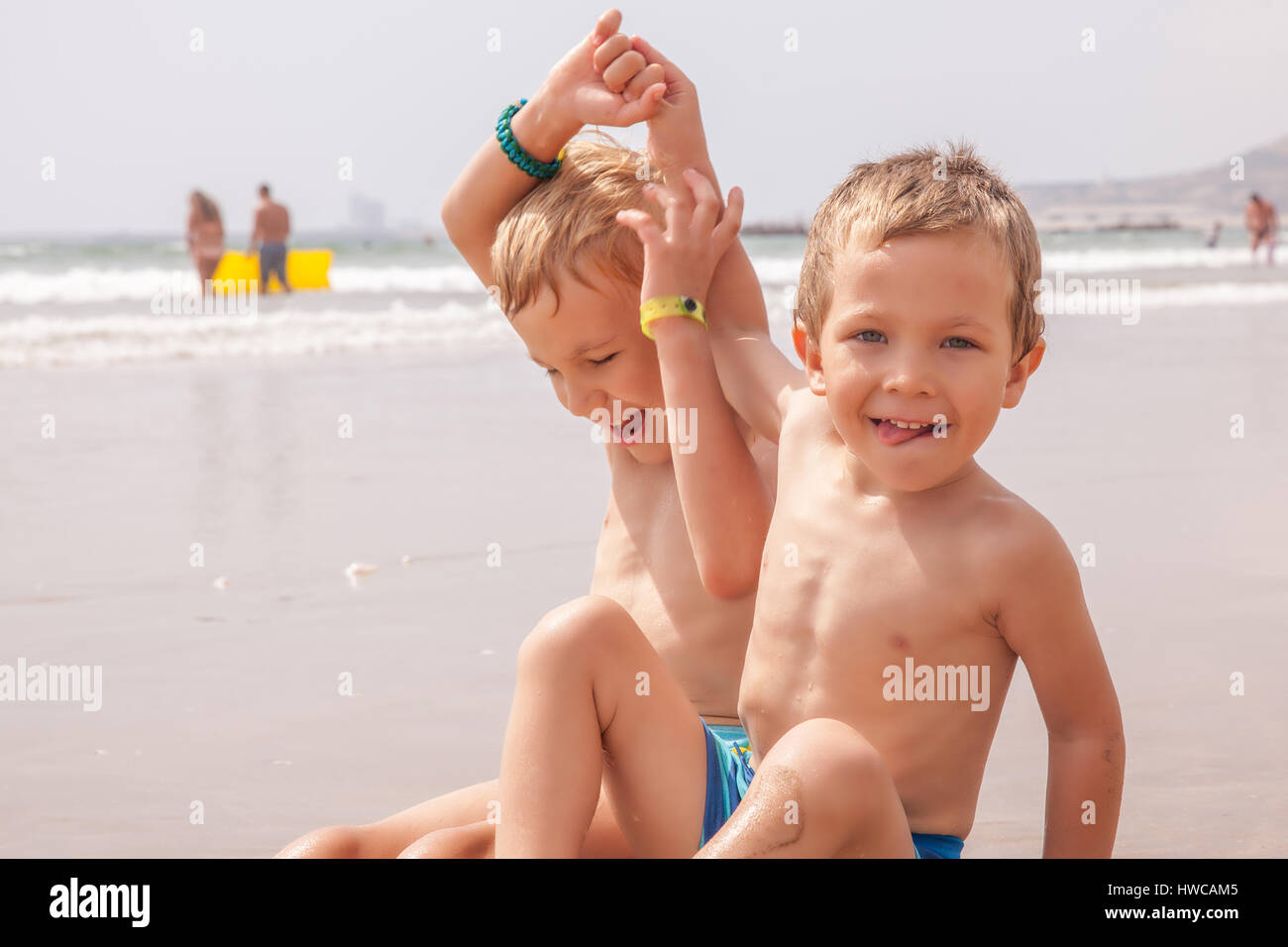 Due graziosi adorabili poco fratelli ragazzi seduto sulla spiaggia mare oceano Foto Stock