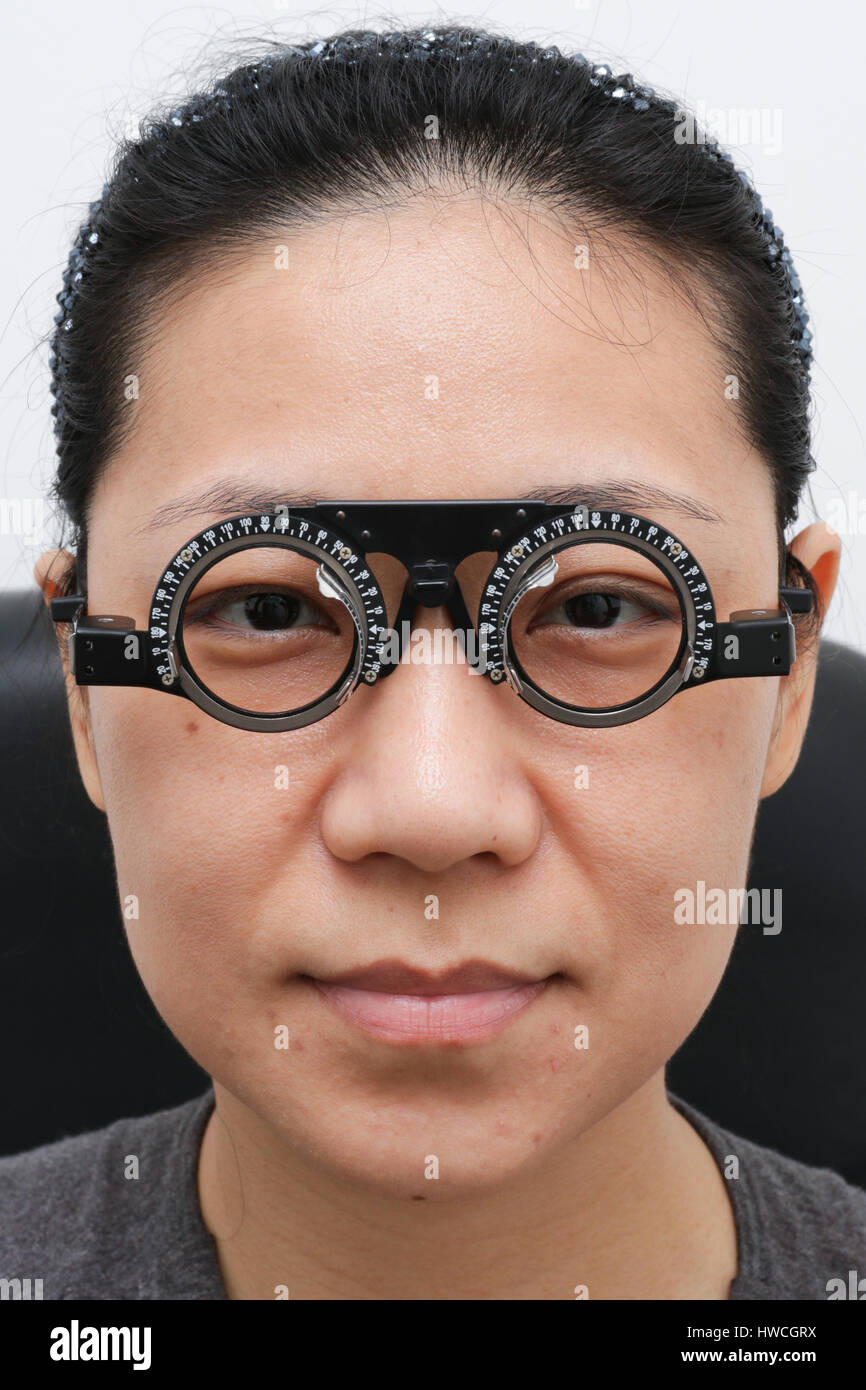 Donna asiatica facendo occhi esame al negozio di Ottica Foto Stock