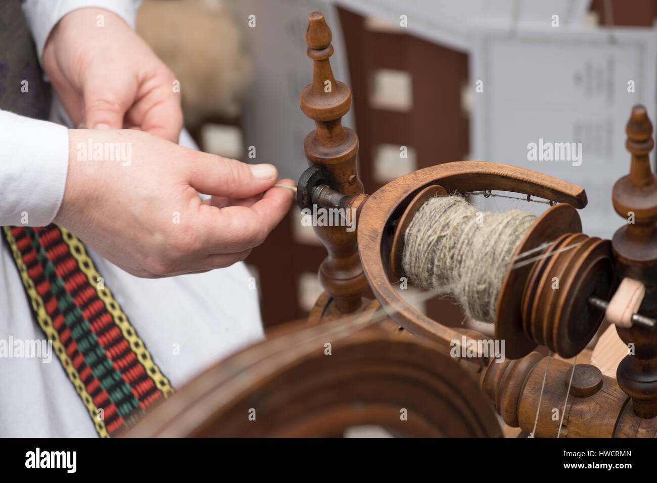 Le mani della donna linea di filatura del lino con una ruota di filatura Foto Stock