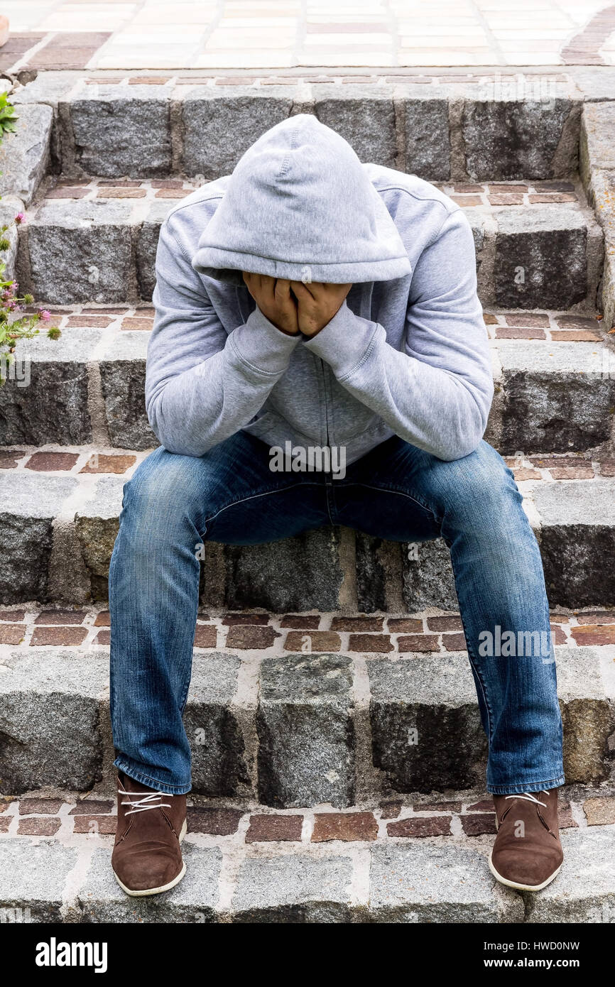 Un uomo si siede solitaria sui gradini, Ein Mann einsam sitzt auf Stufen Foto Stock