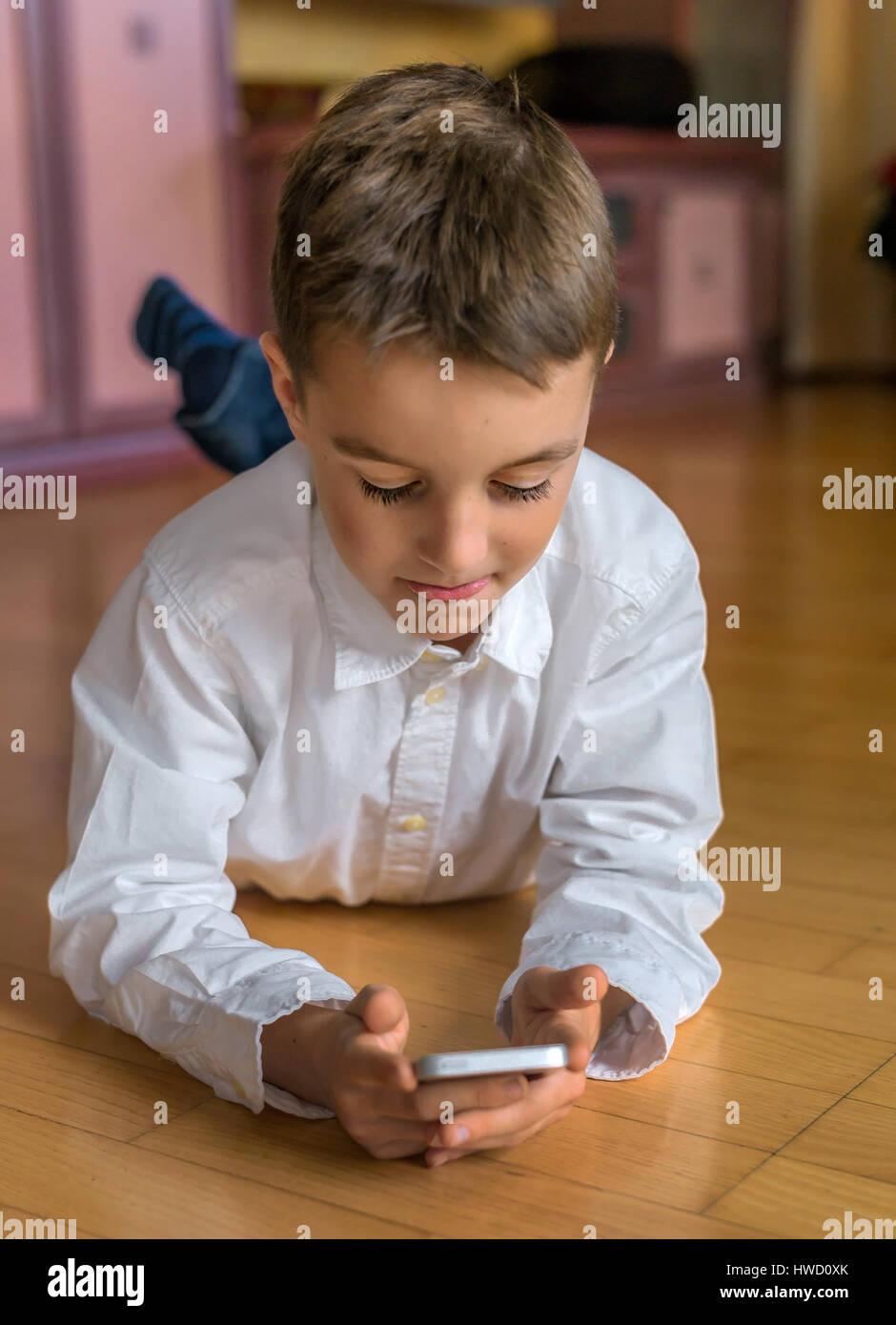 Un bambino gioca con un telefono cellulare. Telefono mobile per i bambini, Ein tipo spielt Mit einem a portata di mano. Mobiltelefon für Kinder Foto Stock