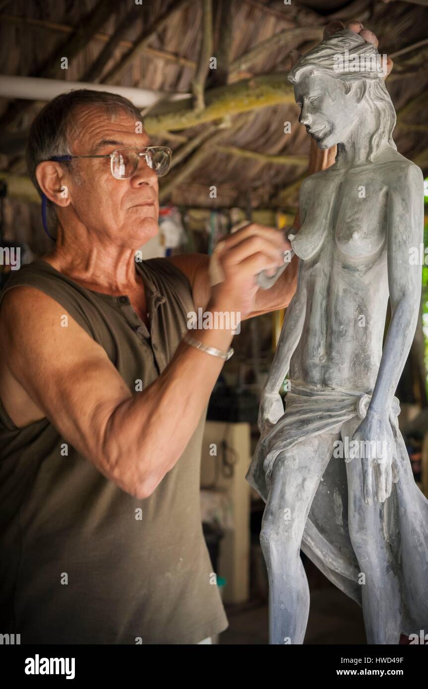 Seychelles, Isola di Mahe, Tom BOWERS carving una giovane ragazza Seychellois nella sua officina, su Les Cannelles strada tra Anse Royale e Anse à la Mouche Foto Stock