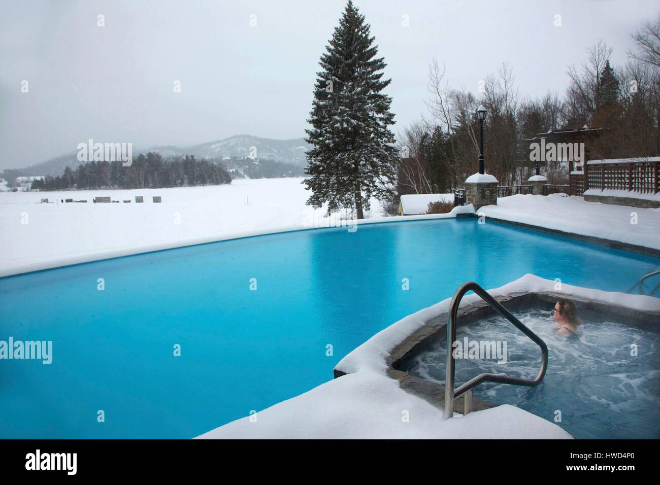 Canada, Québec provincia, regione Laurentians, Mont Tremblant, hotel la quintessenza, donna in un bagno nordico di fronte alla piscina dell'hotel e un lago ghiacciato Foto Stock