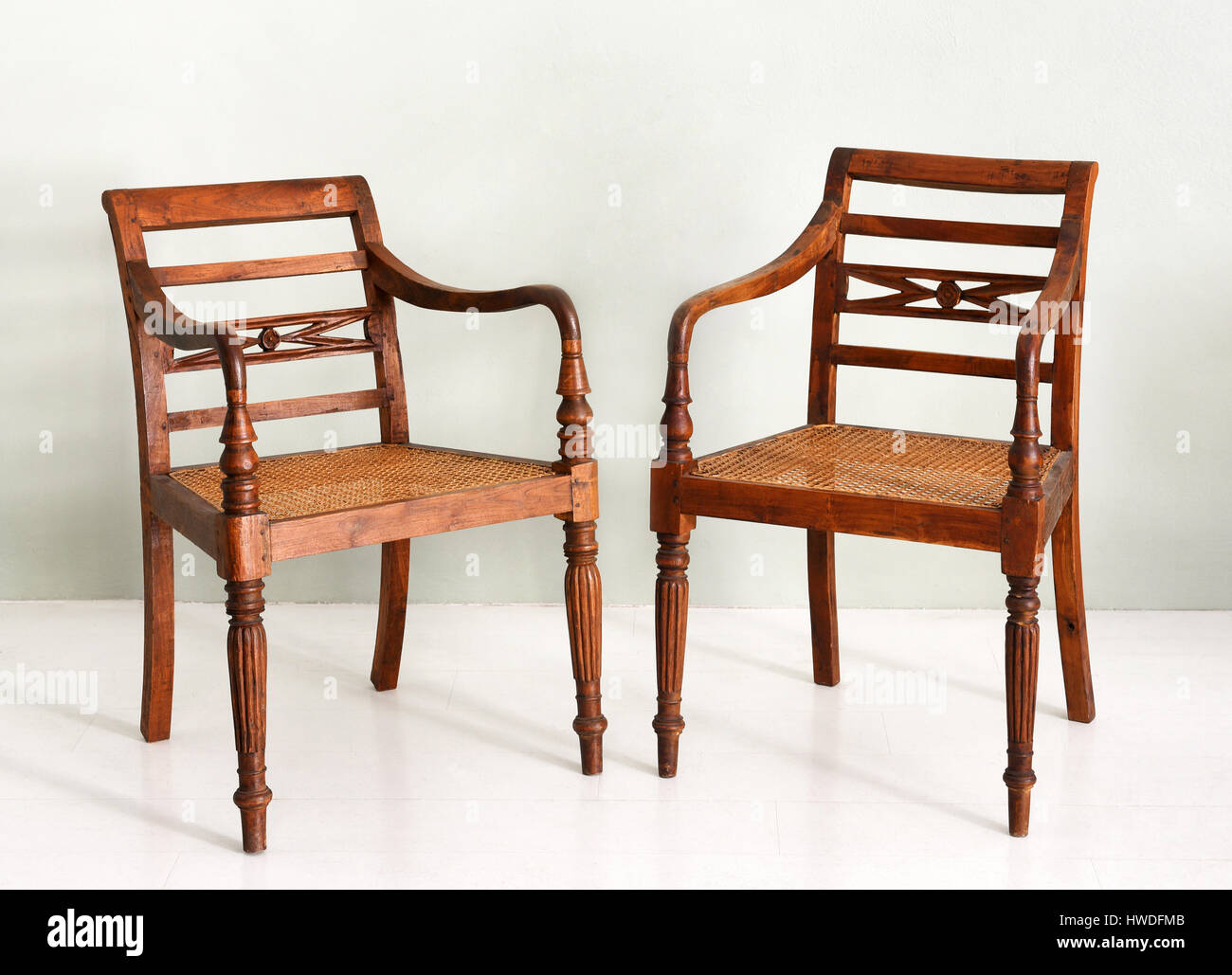 Due vintage stile coloniale poltrone in legno con mandrino forma gambe e in  vimini o sedi di canna, eventualmente server da un set da pranzo Foto stock  - Alamy