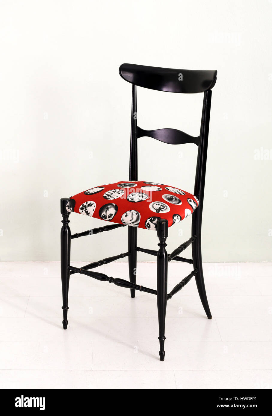 Elegante nera designer italiano Fornasetti sedia con un modellato in grassetto rosso seduta imbottita e una cornice elegante Foto Stock
