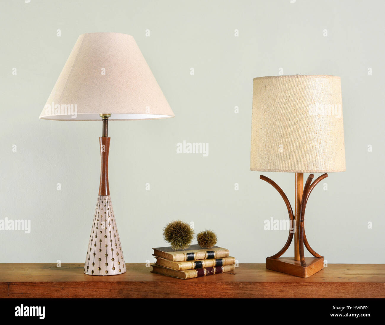 Libri sullo scaffale di legno tra due vintage house luci con stile classico paralumi Foto Stock
