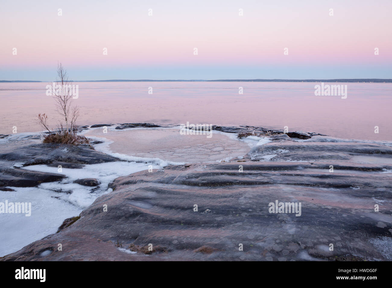 Congelati rock lake shore al crepuscolo Foto Stock