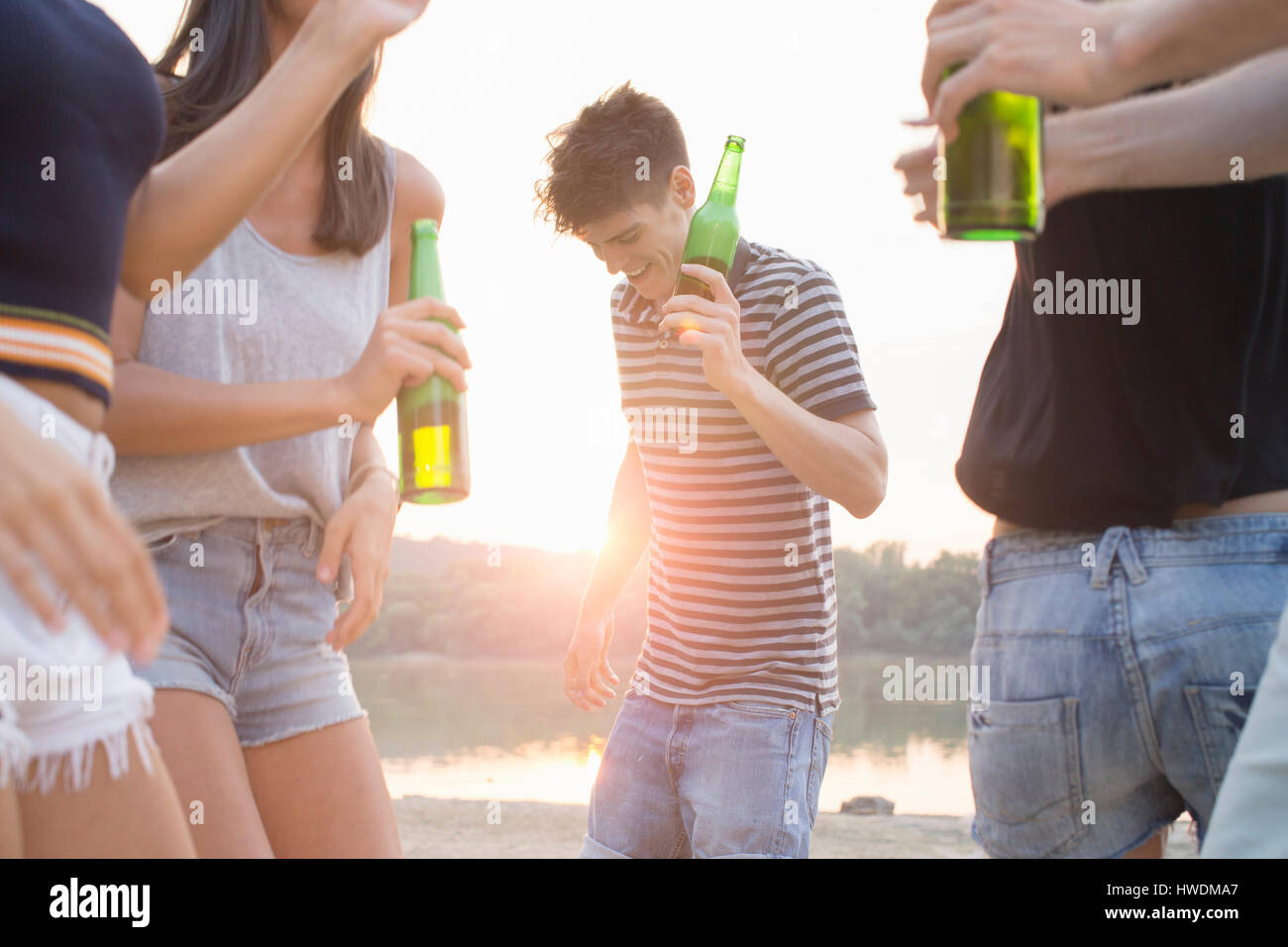 Gruppo di amici di bere, godendo di festa in spiaggia Foto Stock