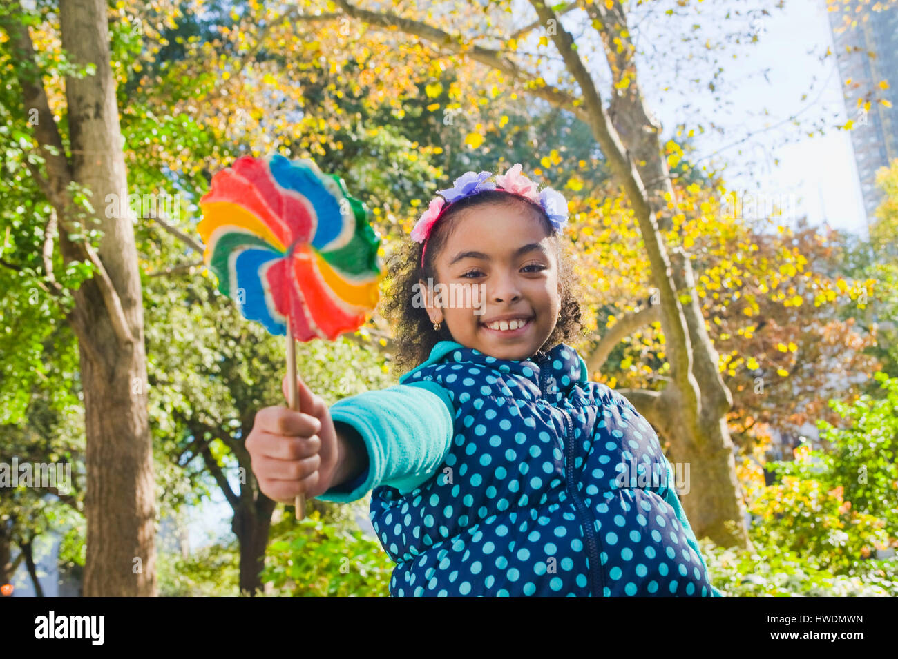 Ragazza con lollipop guardando sorridente della fotocamera Foto Stock
