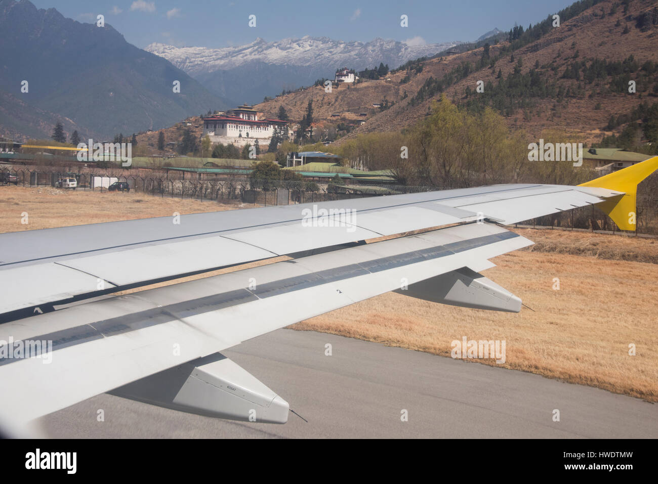 Il Bhutan, Paro. Paro Airport, è l'unico aeroporto internazionale nel Regno del Bhutan. Antica torre di avvistamento, Ta Dzong, sede del Museo Nazionale di B Foto Stock