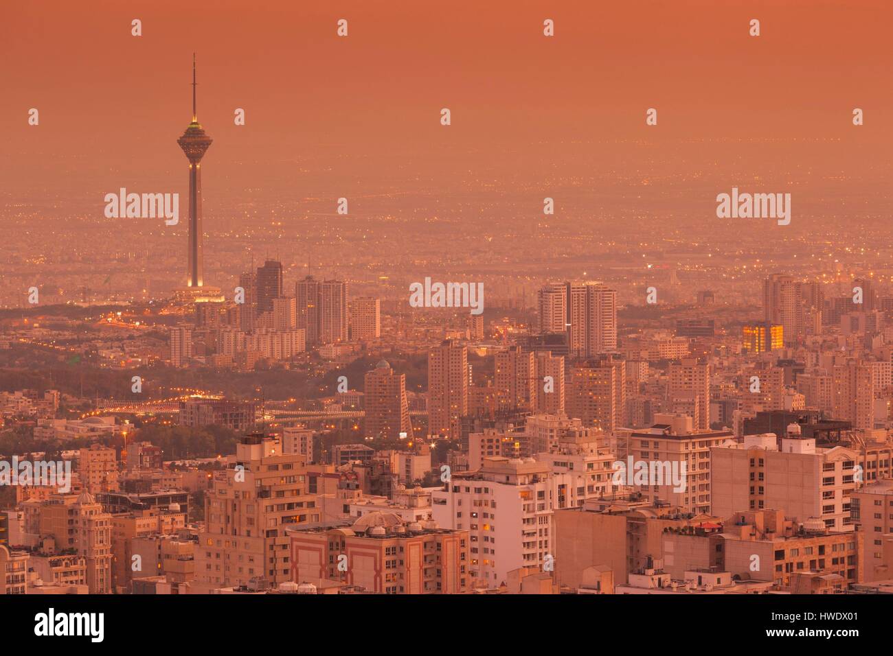 Iran, Teheran, elevati dello skyline della città con vista tfrom il tetto dell'Iran Park verso la torre di Milad, crepuscolo Foto Stock