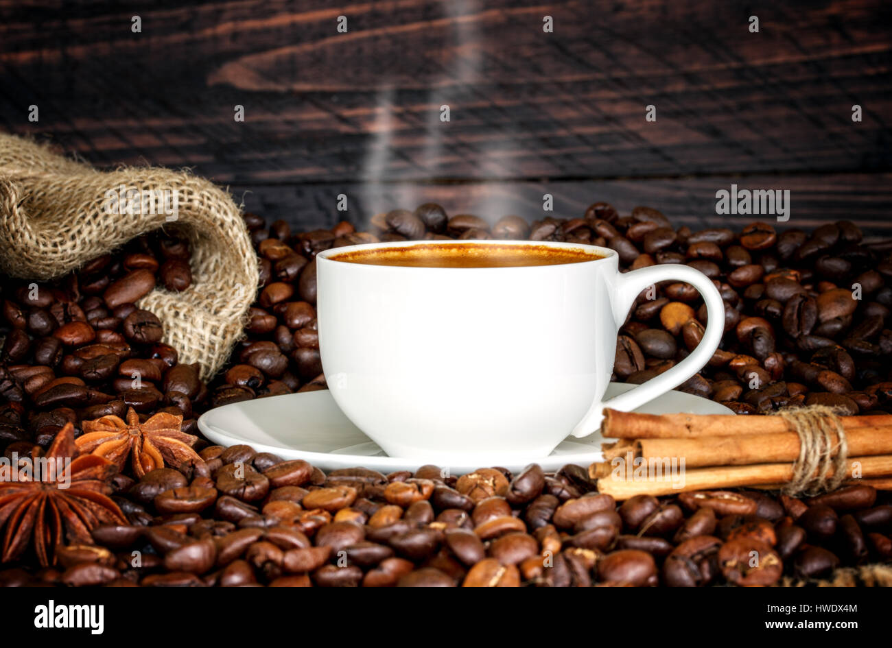 Tazza di caffè e caffè in grani su sfondo di legno. Foto Stock