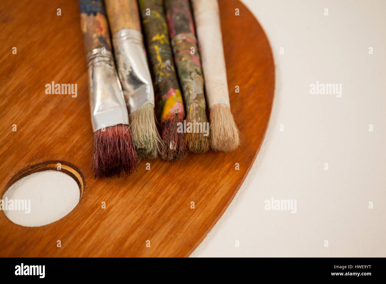 Palette di legno e pennelli su sfondo bianco Foto Stock