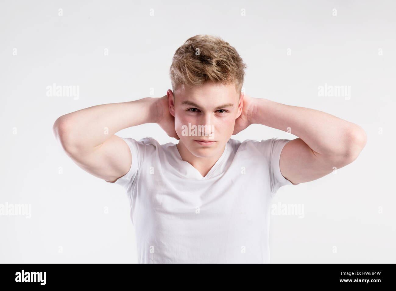 Giovane bello hipster uomo in bianco t-shirt, studio shot. Foto Stock