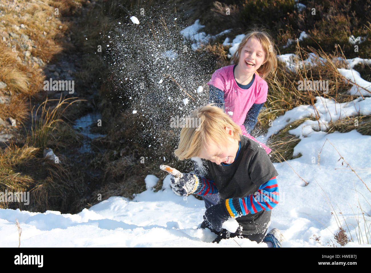 Bambini aventi una palla di neve lotta con il pieno impatto Foto Stock