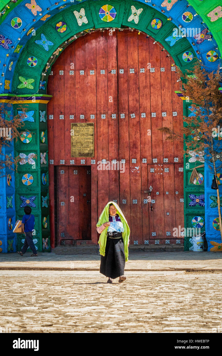Una donna indigena in abito tradizionale passeggiate fuori della chiesa di Chamula, Chiapas, Messico. Foto Stock