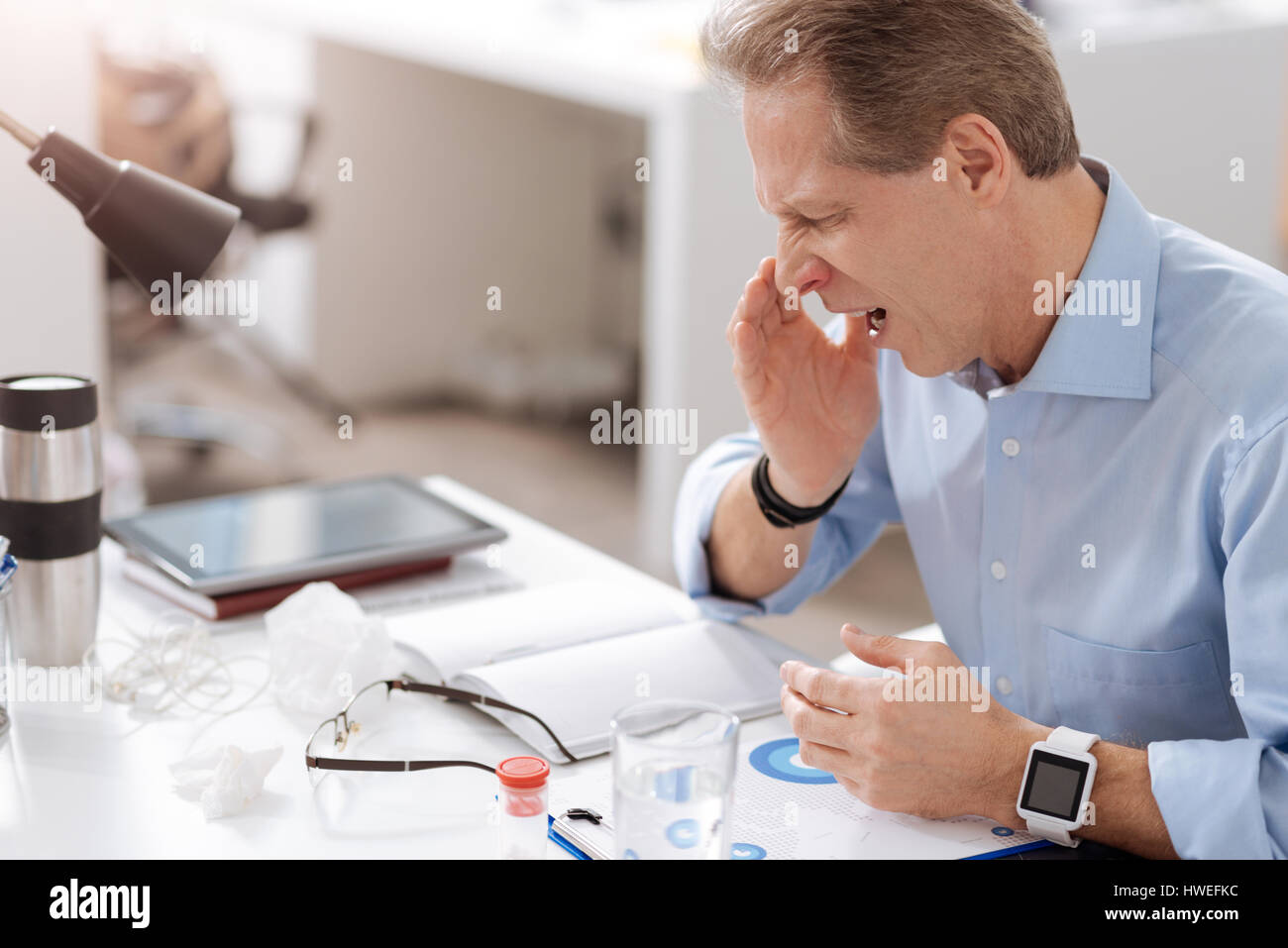 Malati lavoratore di ufficio mentre starnuti Foto Stock