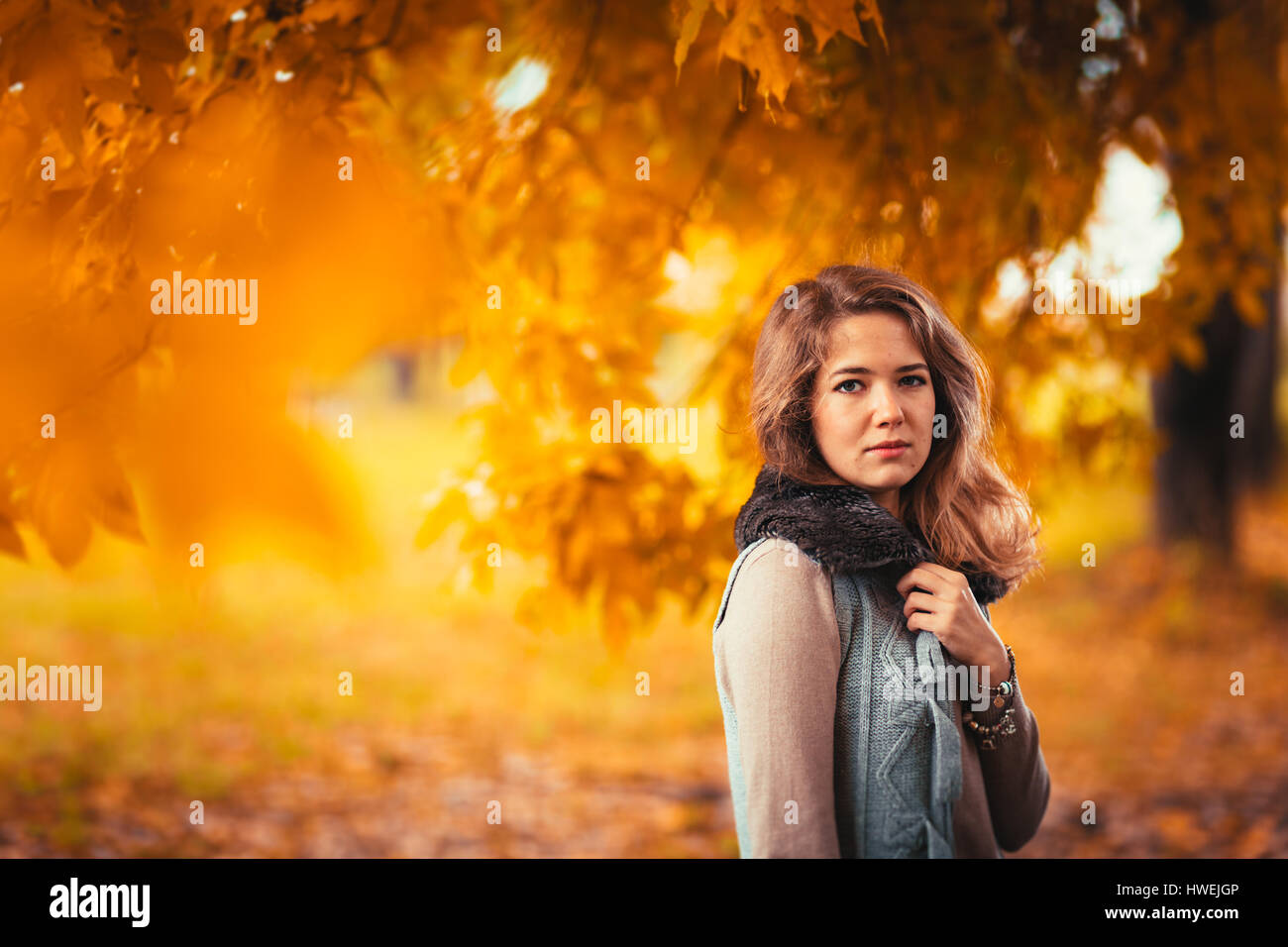 Ritratto di una giovane ragazza nel giubbotto di pelliccia su sfondo autunno park Foto Stock